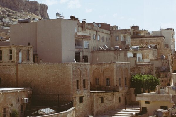 Stone buildings line a sunny street.