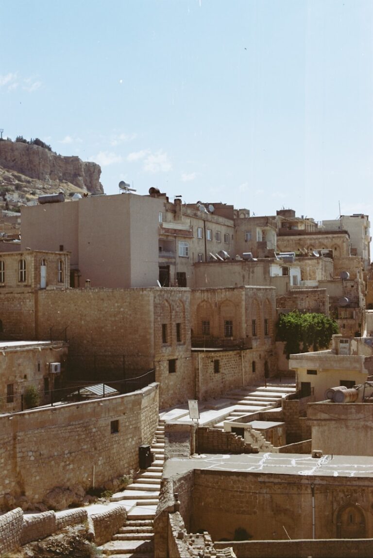 Stone buildings line a sunny street.